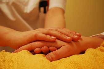 Close-up of hands holding for comfort and care