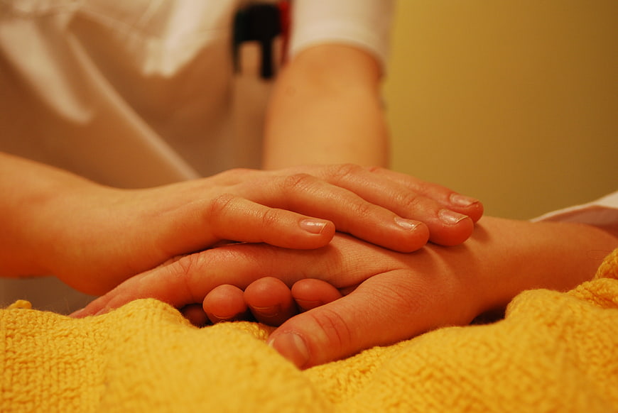 Close-up of hands holding for comfort and care