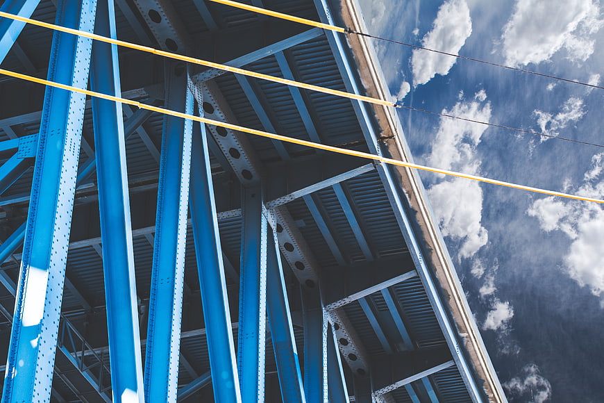 Low angle view of blue steel bridge structure against sky