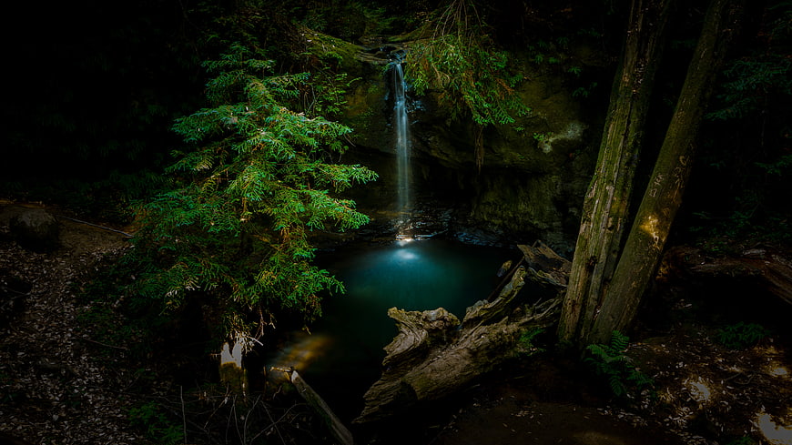 Mysterious Dark Forest Waterfall with Glowing Pool