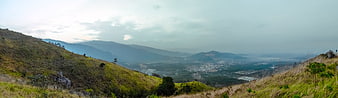 Panoramic View of Mountain Valley with City and Clouds