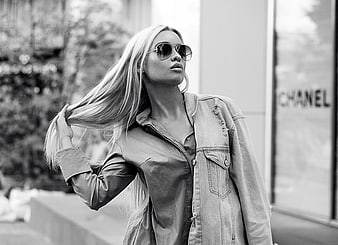 Stylish blonde woman in sunglasses and denim jacket