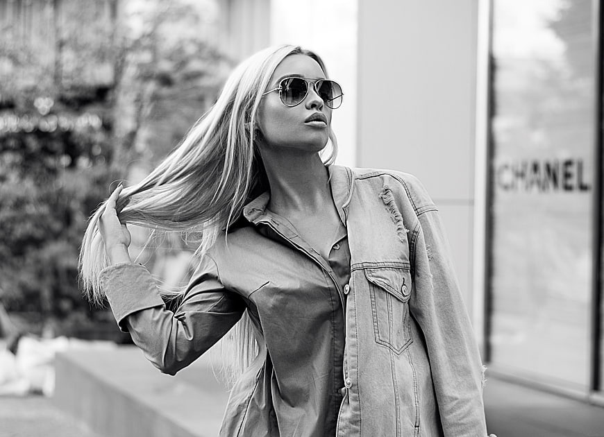 Stylish blonde woman in sunglasses and denim jacket