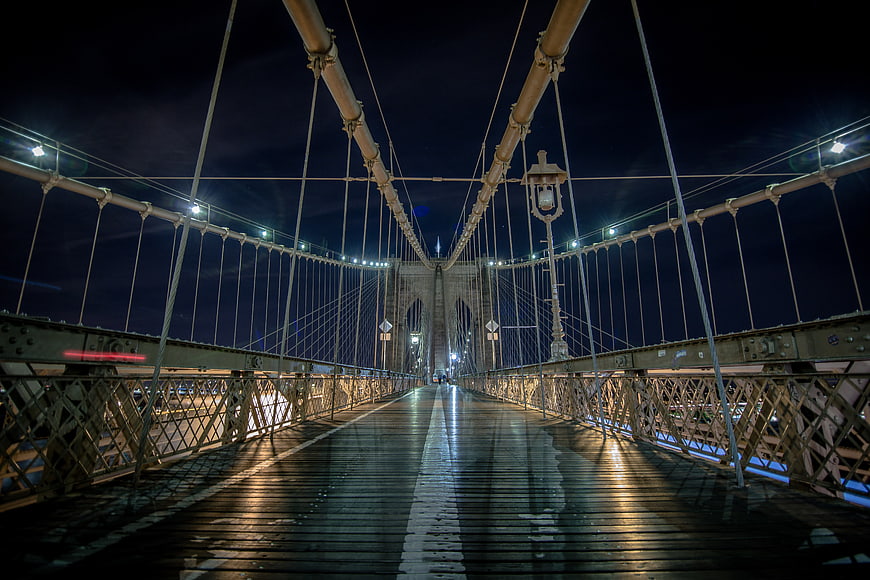 Night view of Brooklyn Bridge pedestrian walkway with lights