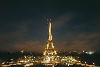 Eiffel Tower Illuminated at Night with Searchlights