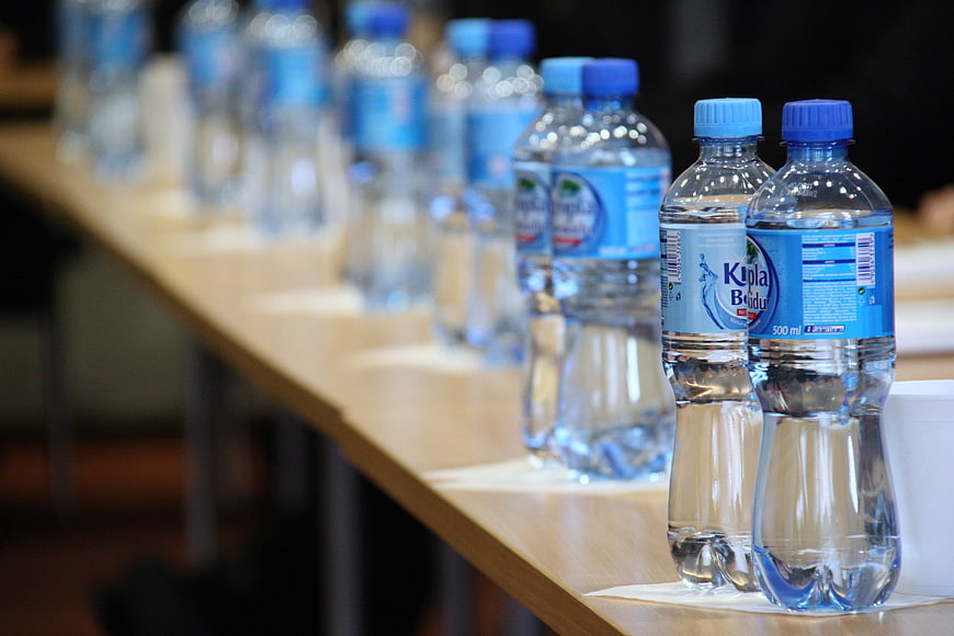 Row of plastic water bottles on a conference table