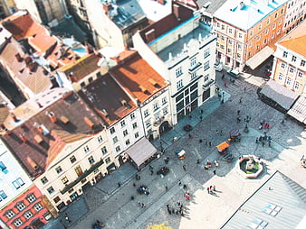 Aerial tilt-shift view of European town square with red roofs