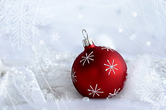 Red Christmas Bauble with White Snowflakes on Snowy Background