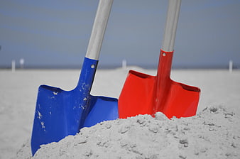 Blue and Red Shovels in Sand