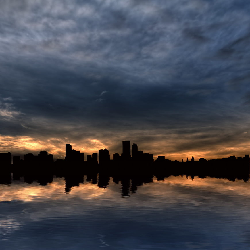 Dramatic City Skyline Silhouette Reflected in Water at Sunset