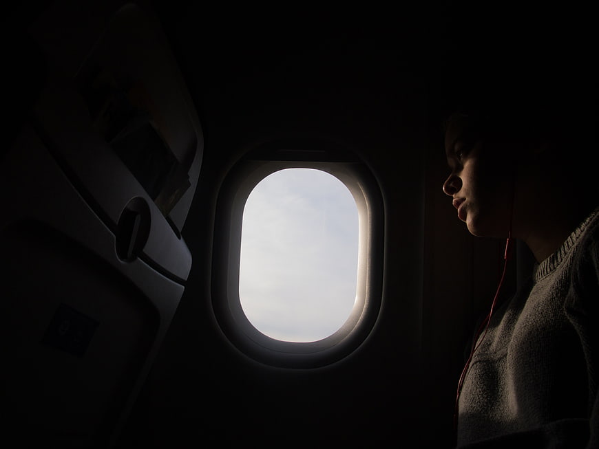 Silhouette of Woman Looking Out Airplane Window