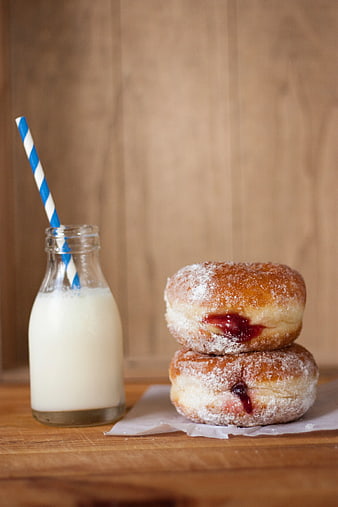 Stacked Jam Donuts with Milk Bottle on Wooden Table