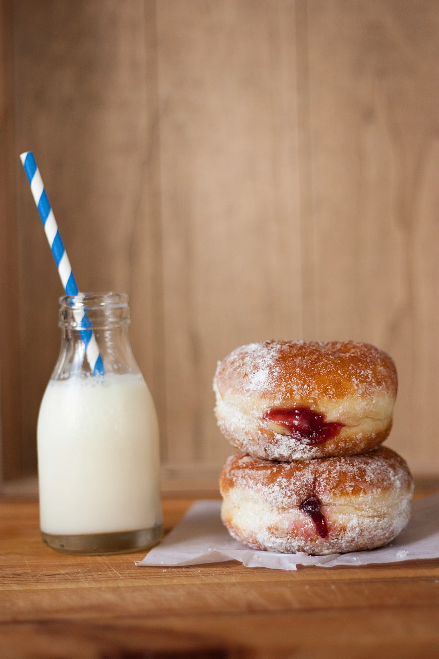 Stacked Jam Donuts with Milk Bottle on Wooden Table