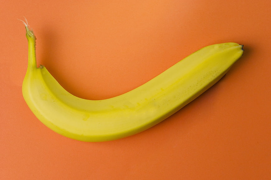 Yellow Banana on Vibrant Orange Background