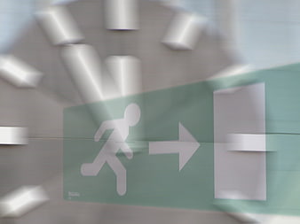 Motion-blurred emergency exit sign on a clock face