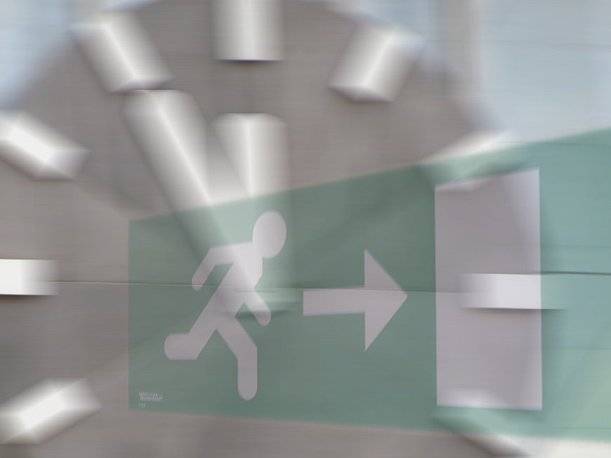 Motion-blurred emergency exit sign on a clock face