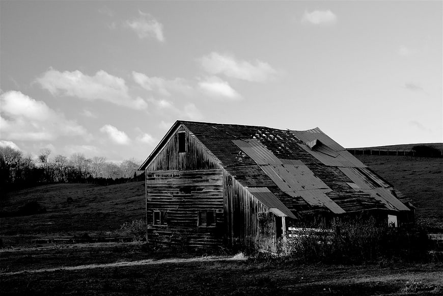 Weathered wooden barn in rural countryside landscape