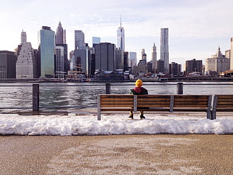 Child in Yellow Hat Sitting on Bench Viewing NYC Skyline