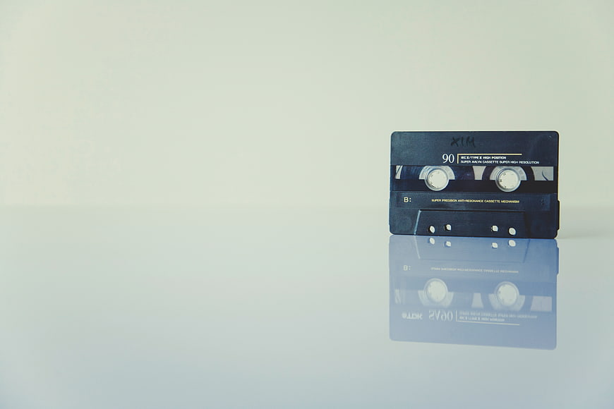 Vintage blue cassette tape with reflection on white background