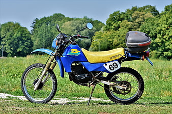 Blue Suzuki TS 50 Enduro Motorcycle Parked In Green Field
