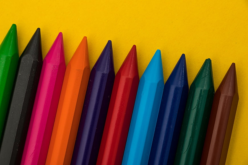 Colorful Crayons Arranged Diagonally On Bright Yellow Background
