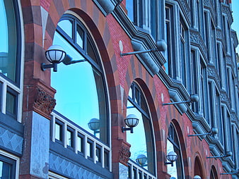 Red brick building facade with arched windows and street lamps