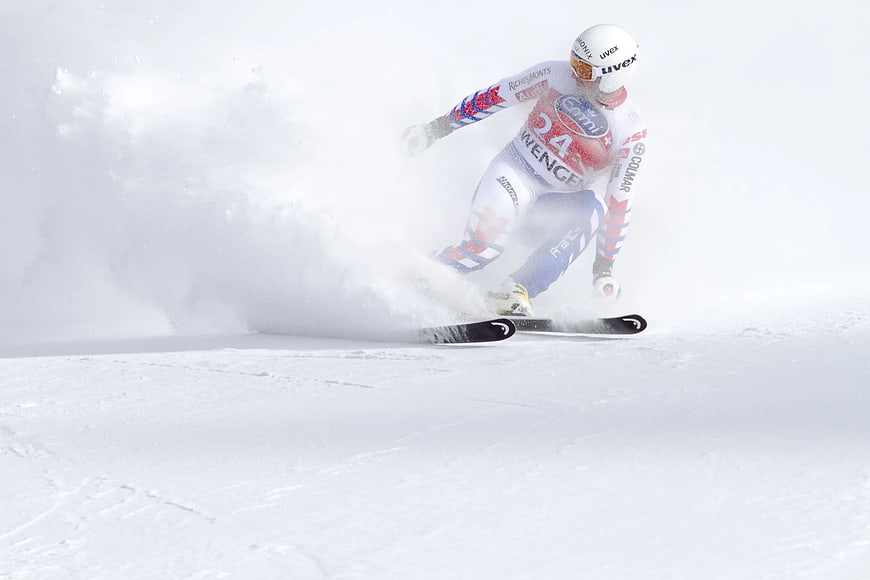 Alpine skier carving turn in powder snow
