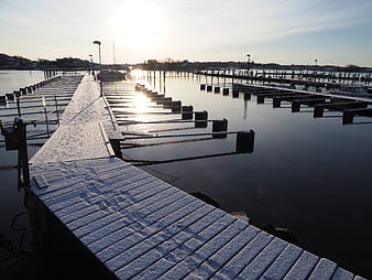 Snow-covered wooden pier at a quiet winter harbor
