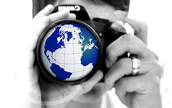 Photographer holding camera with globe lens concept