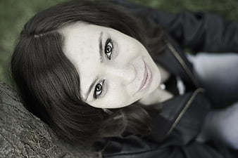 Close-up portrait of smiling woman lying on grass