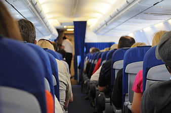 Passengers seated in airplane cabin aisle view