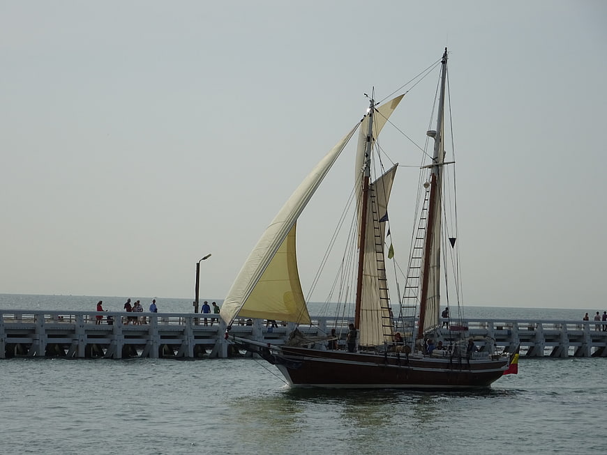 Traditional two-masted sailing ship near pier