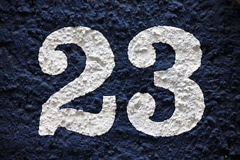 White Number 23 Painted On Textured Dark Blue Stucco Wall