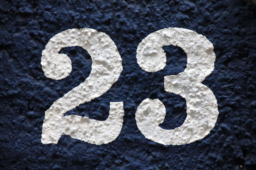 White Number 23 Painted On Textured Dark Blue Stucco Wall