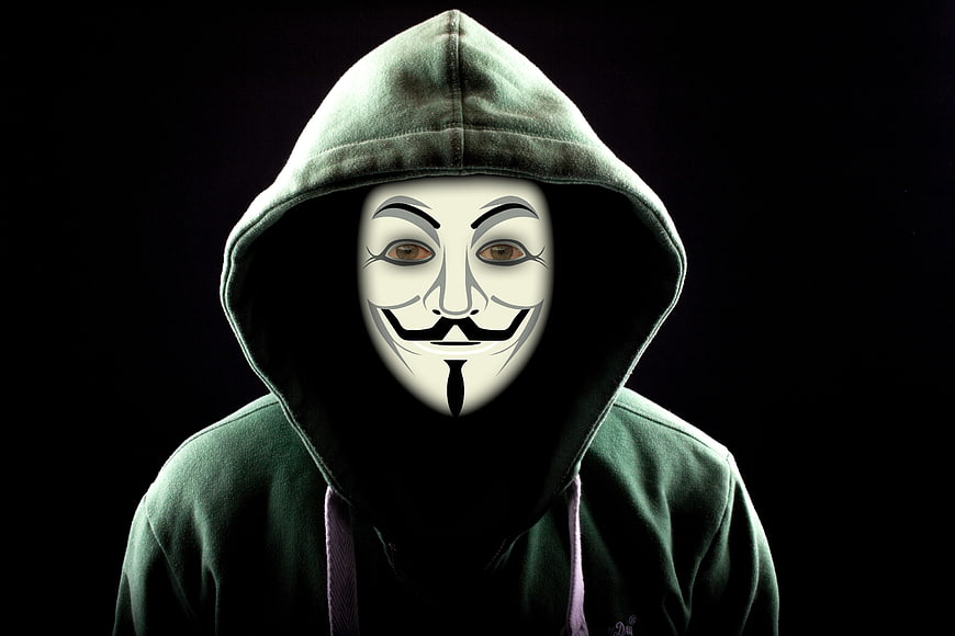 Anonymous Hacker in Green Hoodie and Guy Fawkes Mask