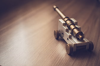 Vintage Brass Toy Cannon on Wooden Surface