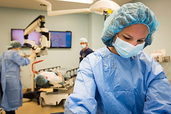 Female Surgeon in Blue Scrubs During Eye Surgery Operation