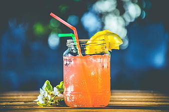 Refreshing Orange Cocktail in Mason Jar with Lemon and Straw