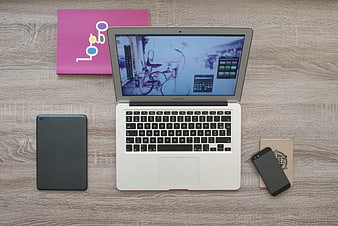Flat lay workspace with laptop, tablet, smartphone, and notebook on wooden desk
