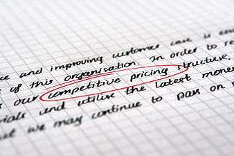 Close-up of handwritten competitive pricing text circled in red on grid paper
