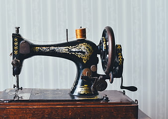 Vintage black sewing machine with gold details on wooden box