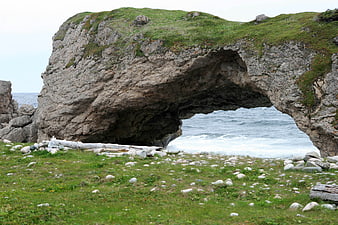 Natural Rock Arch Overlooking Ocean Waves and Grassy Shore