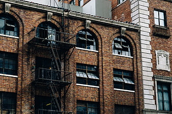 Urban brick building facade with fire escape and arched windows