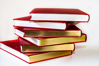Stack of red hardcover books with gold edges on white background