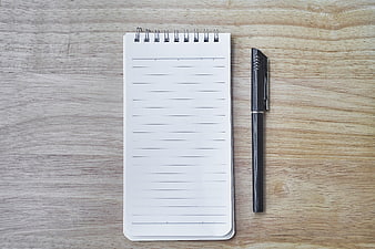 Top View of Blank Spiral Notebook and Black Pen on Wood
