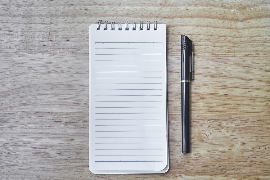 Top View of Blank Spiral Notebook and Black Pen on Wood