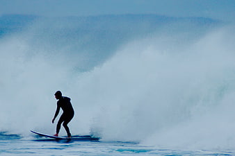 Surfer riding a massive wave in the ocean