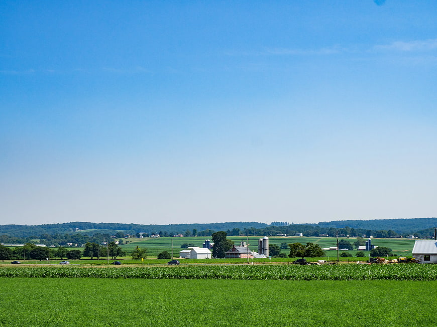 Wide rural landscape with green fields and farm buildings