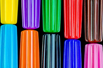 Close-up of colorful ribbed plastic pen caps on black background