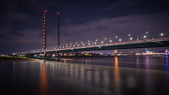 Illuminated cable-stayed bridge over river at night